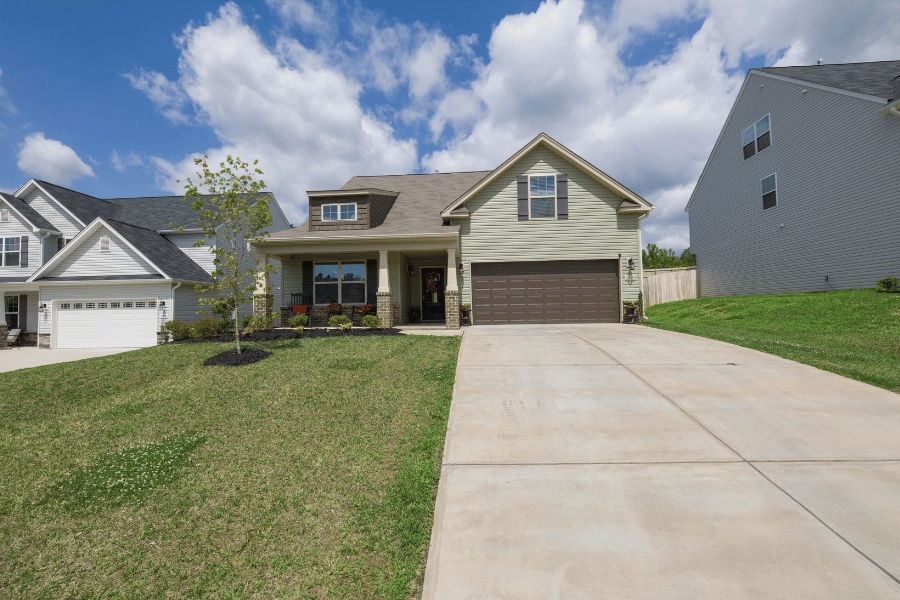 cute home with brown garage and front porch in a suburban neighborhood